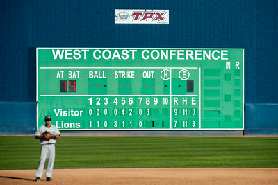A baseball player in a white uniform stands in front of a large scoreboard, he is a prevention advocate and the other team is Big Alcohol